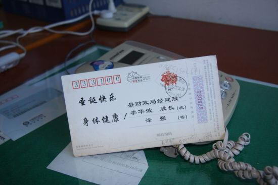 李华波逃跑前没有处理办公室,一张明信片孤零零的留在桌上。
