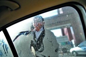 昨日,北太平庄派出所,当事律师在查看车玻璃上的脚印,他报警称深夜遭袭。本报记者 杨杰 摄 昨日,北太平庄派出所,当事律师在查看车玻璃上的脚印,他报警称深夜遭袭。本报记者 杨杰 摄
